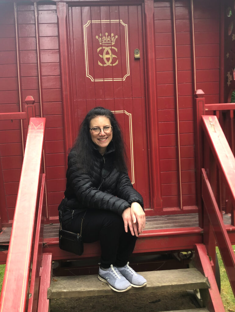 Melody Moser sitting a red gypgy wagon in Scotland.