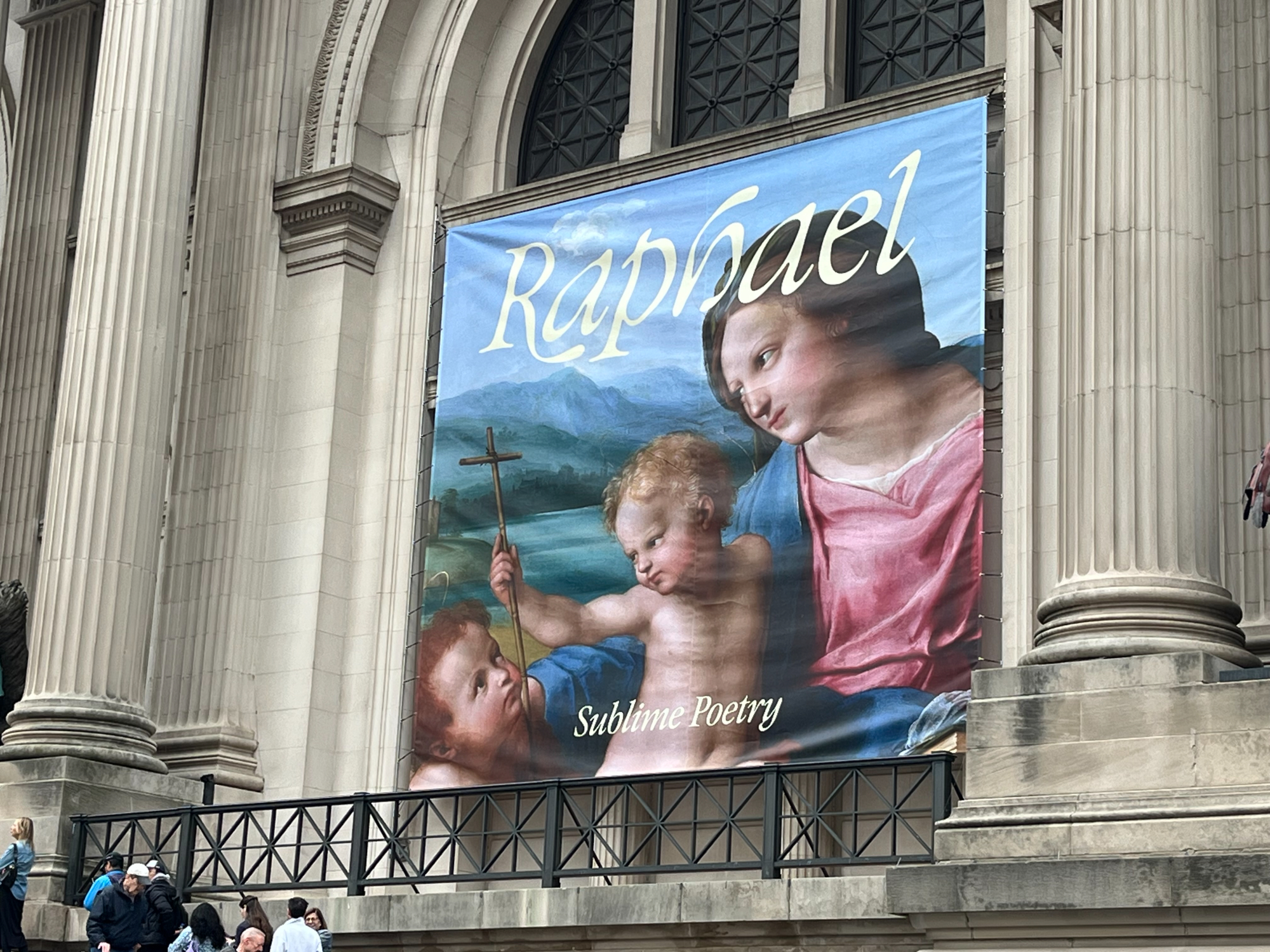 The Metropolitan Museum of Art entrance with a large Raphael Sublime Poetry exhibit sign
