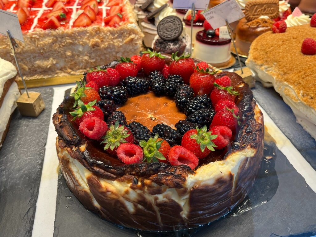 Chocolate cake topped with berries in a bakery window in Covent Garden.