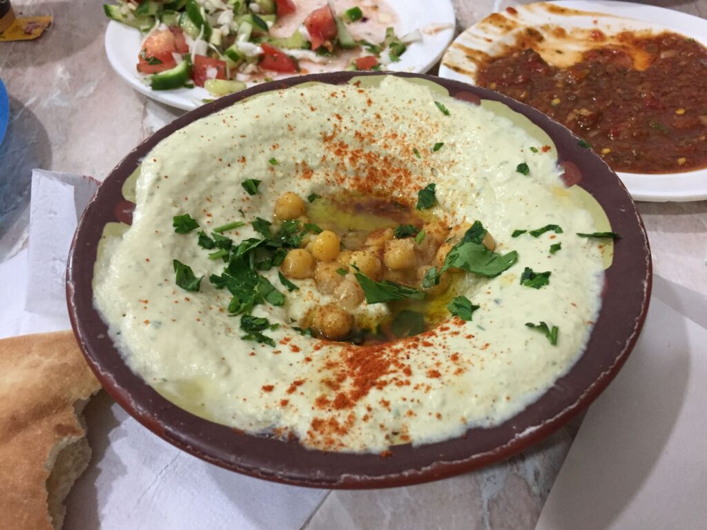 Bowl of hummus topped with chickpeas, olive oil, herbs and paprika at Abu Shukri in Jerusalem’s Old City