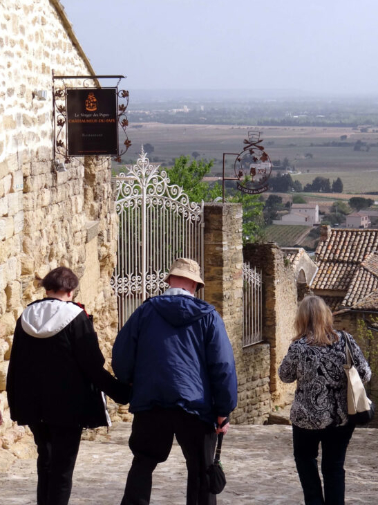 Wine tour participants walking through the hilltop village of Châteauneuf-du-Pape, France.