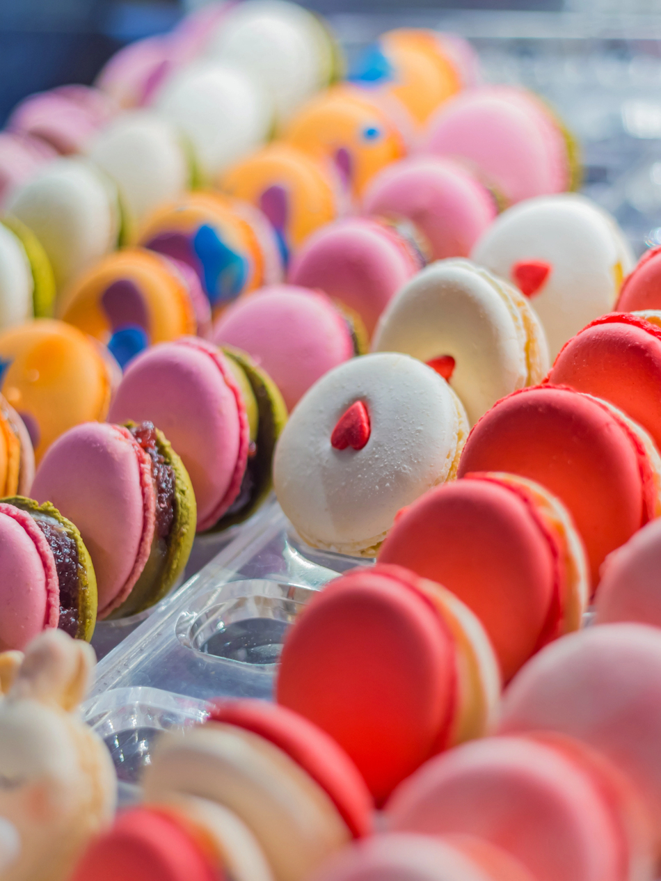 Colorful French macarons arranged in rows in a pastry display